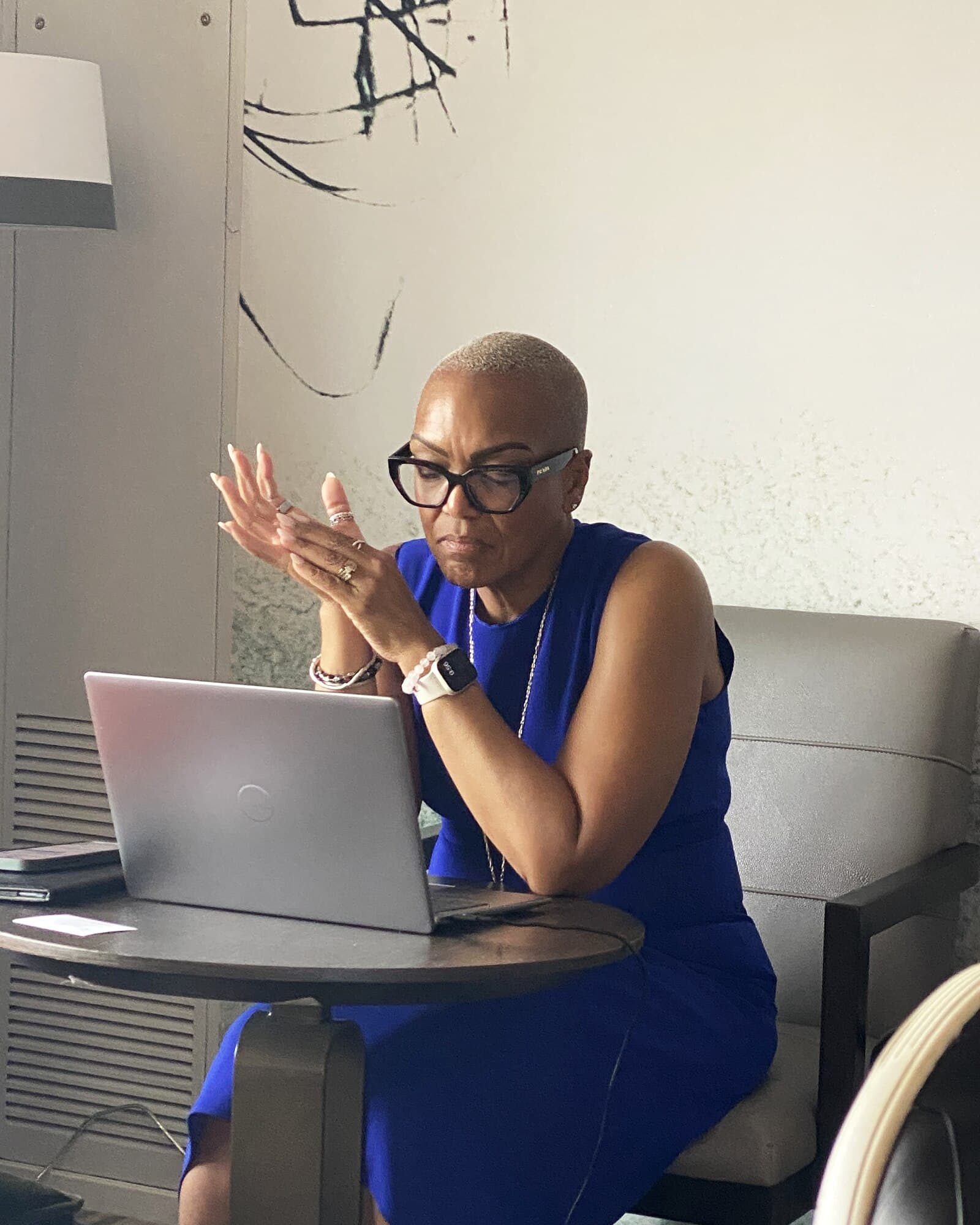 Cheryl Baptiste at work, mid thought, in a blue dress
