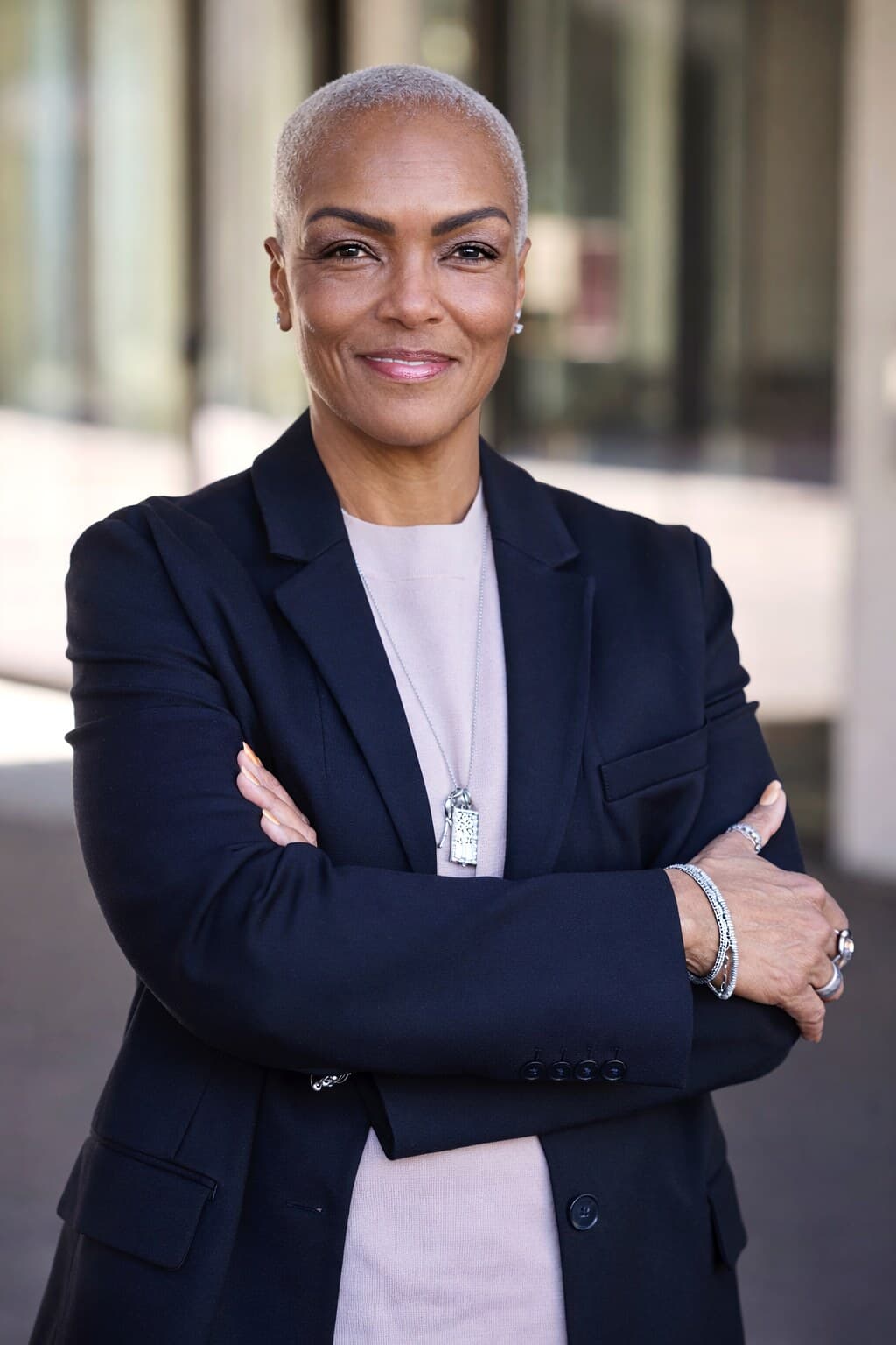 Cheryl Baptiste, arms crossed, in a navy blazer